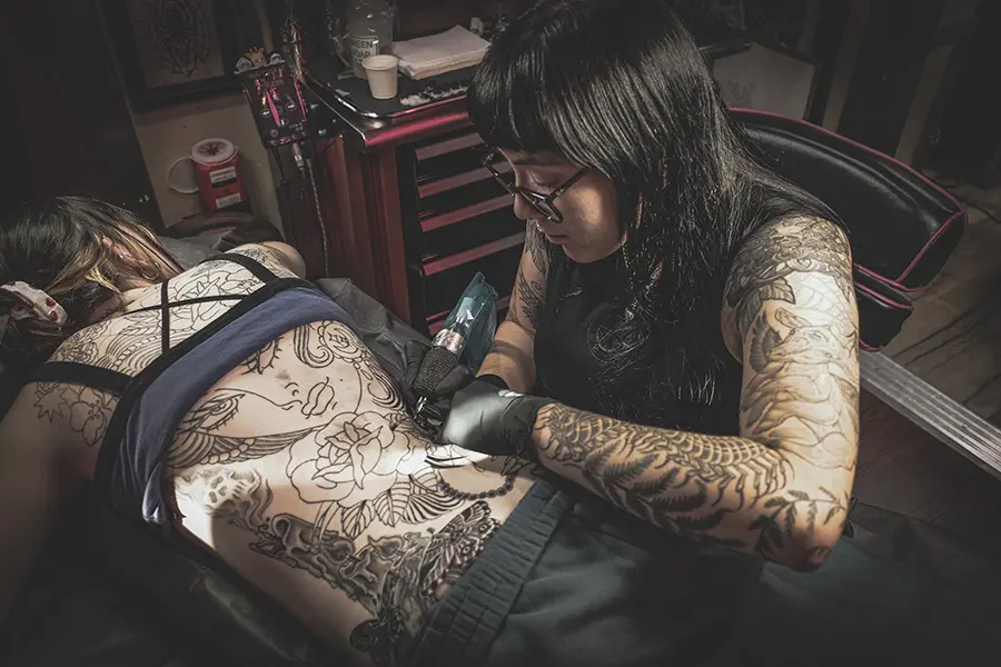 Tattooer Coral working on a backpiece